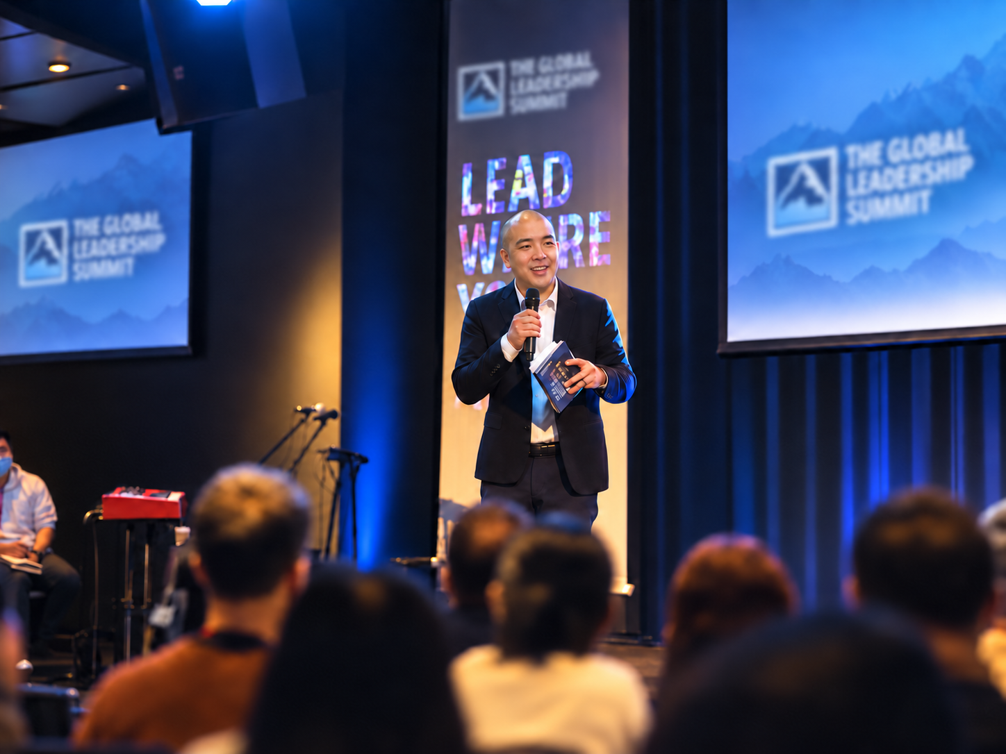 Norbert Woo speaking at a global leadership summit, seen from across the room